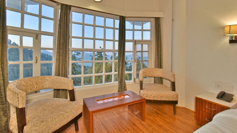 Seating area with two chairs placed next to the bed at DLS Hillcrest Resort, Shimla.